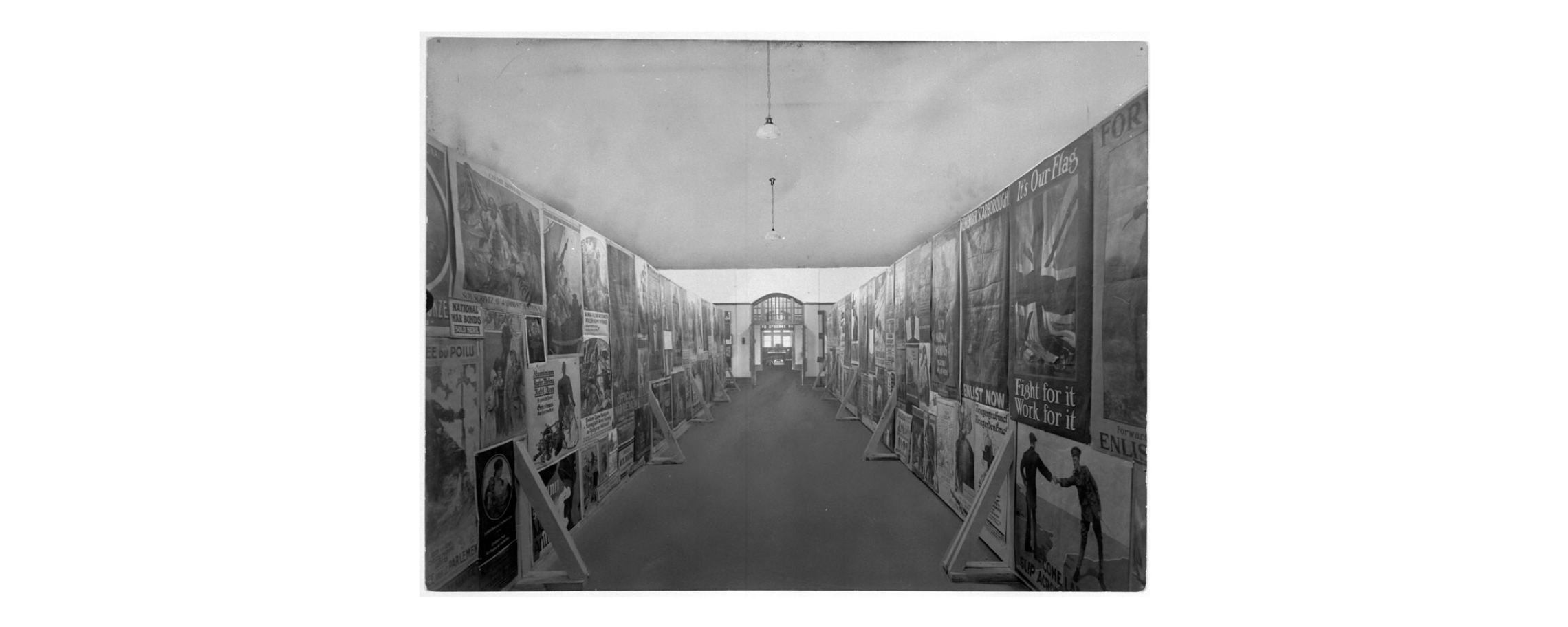 A black and white photo of a hallway with posters in the Canadian War Museum, located in Ottawa.