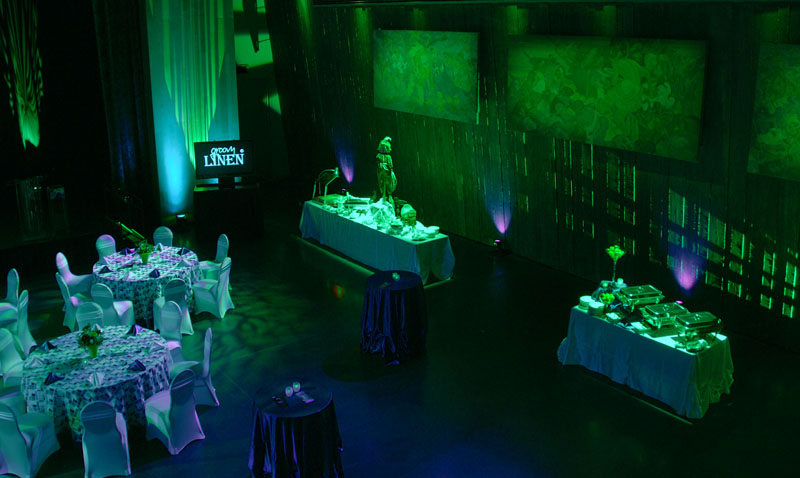 A green light in the Barney Danson Theatre with tables and chairs in Ottawa.