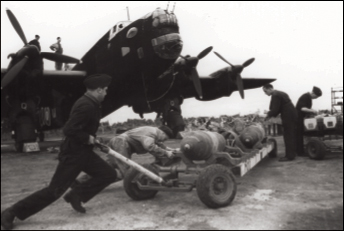 Men in the airforce loading munitions onto a bomber.