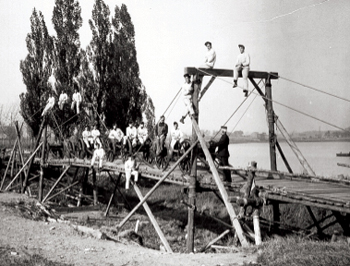 A group of men standing on a wooden bridge.