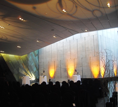 A group of people are sitting at a table in the Canadian War Museum.