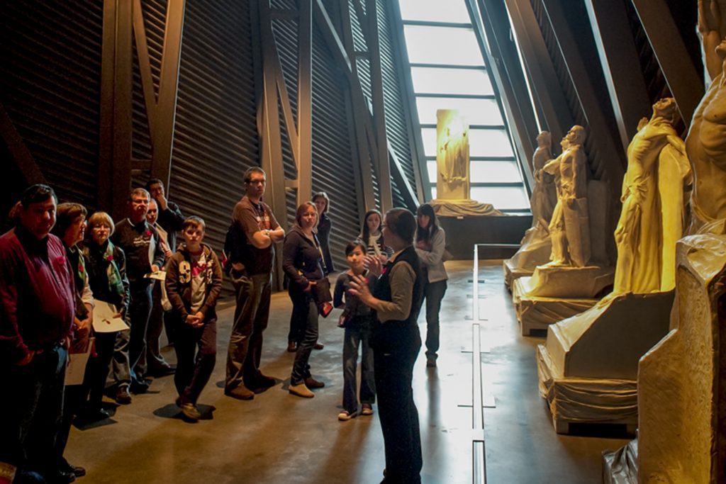 A group of people visiting the Canadian War Museum in Ottawa, observing statues.