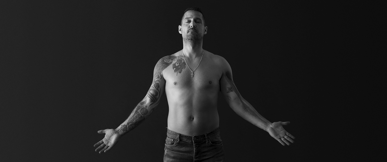 A black and white photo of a man with tattoos taken at the Canadian War Museum in Ottawa.