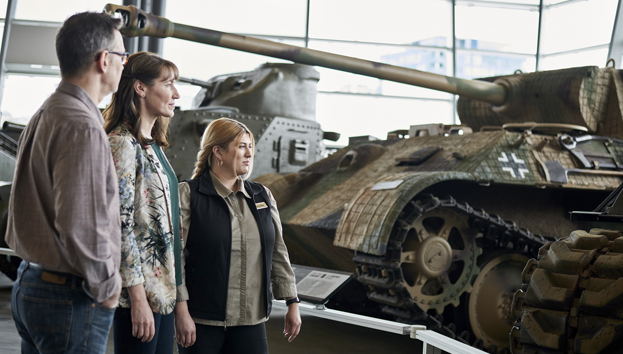 Three people exploring a tank at the Canadian War Museum in Ottawa.