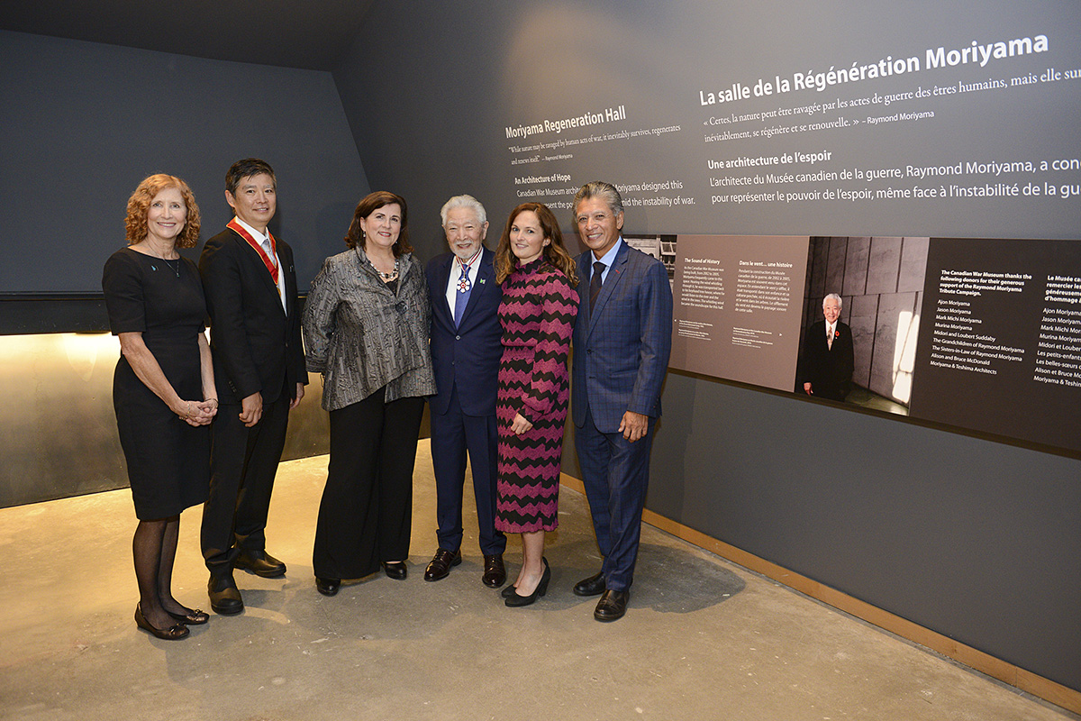 A group of people posing in front of a wall display at the Canadian War Museum in Ottawa.