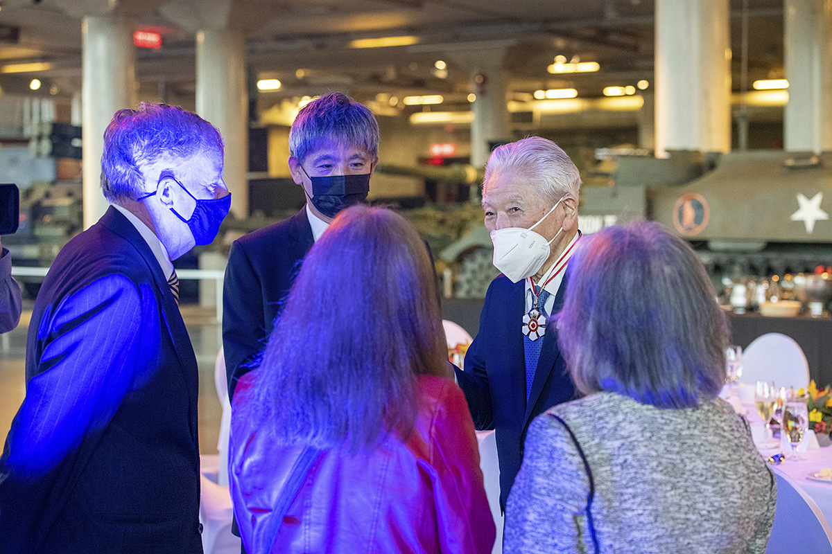 A group of people standing around a table wearing masks at the Canadian War Museum in Ottawa.