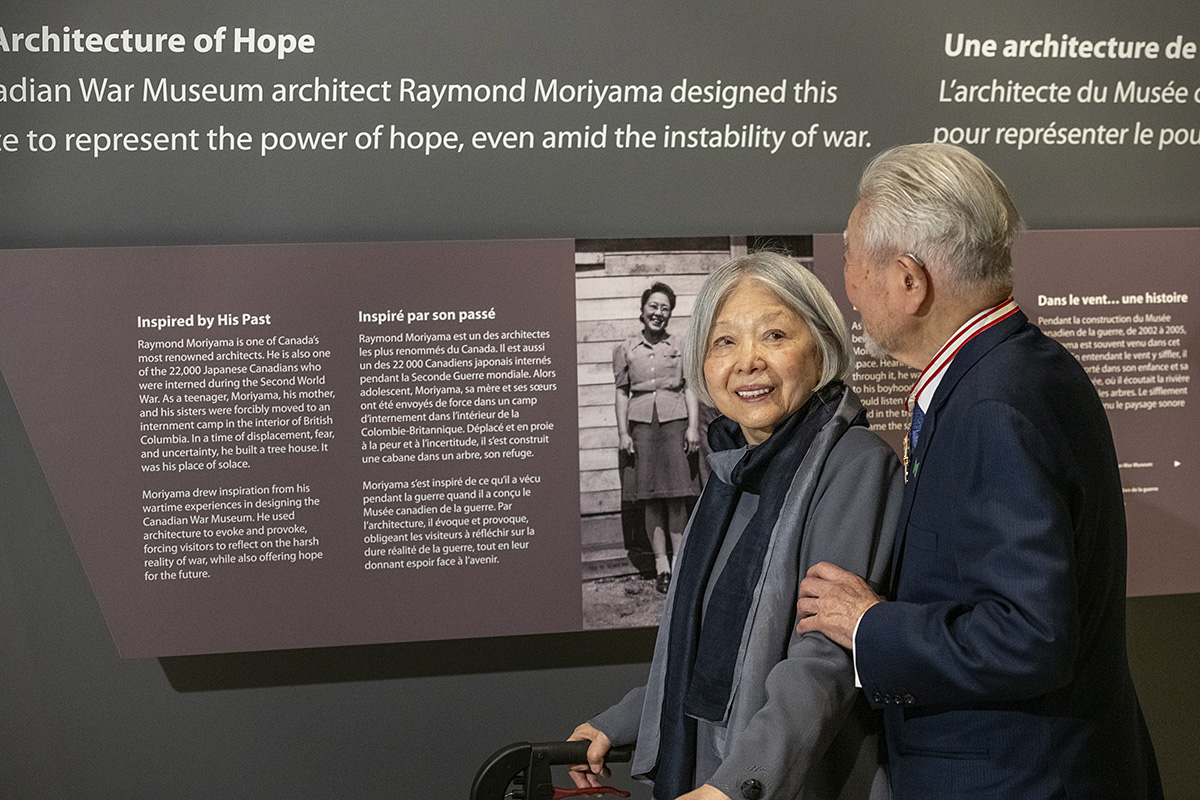 A man and woman in Ottawa look at a display about the architecture of hope in the Canadian War Museum.