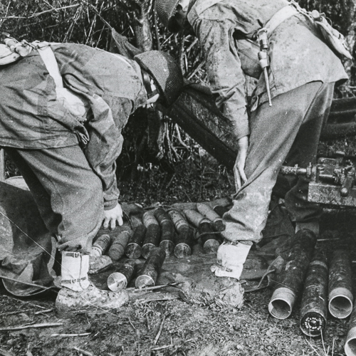 A group of soldiers are looking at a pile of cans in the Canadian War Museum.