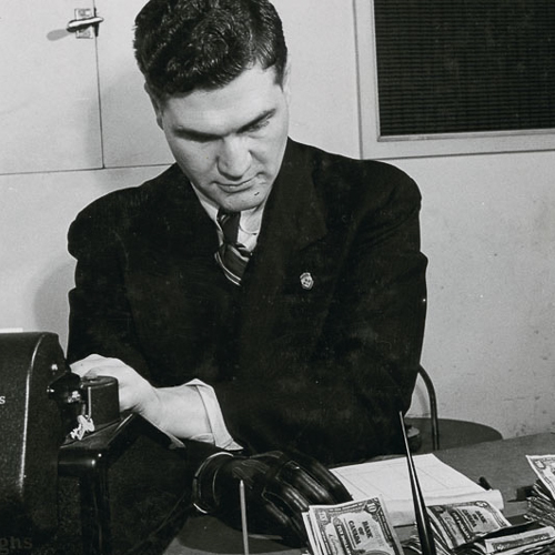 A man in a suit sitting at a desk at the Canadian War Museum in Ottawa.