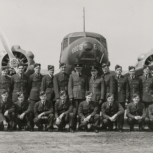 A group of aviators posing in front of a bomber