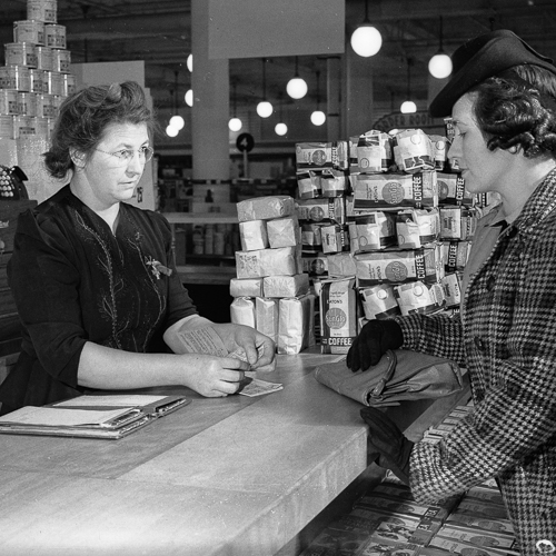 Two women standing at a counter talking to each other in the Canadian War Museum.