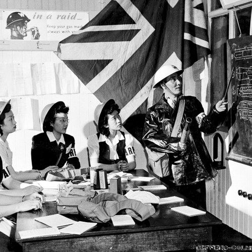 A group of women sitting around a table with a blackboard.