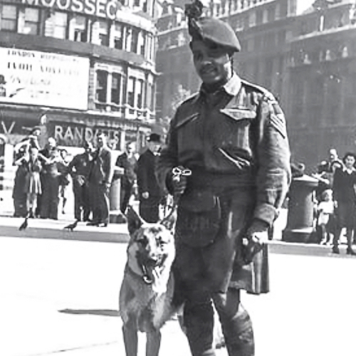 A man in a kilt standing next to a dog in Ottawa.