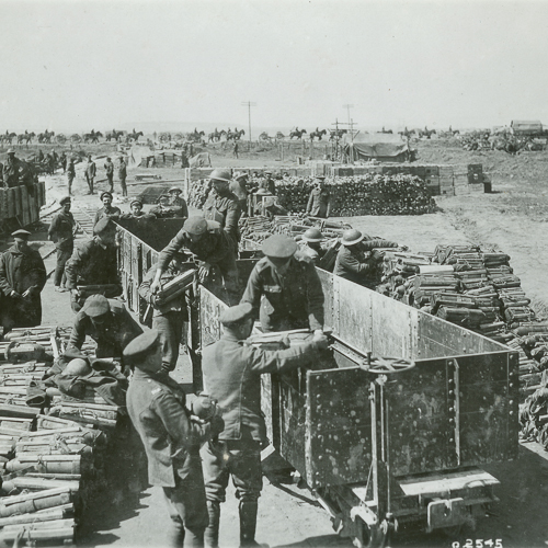 A group of men are loading wood onto a truck.