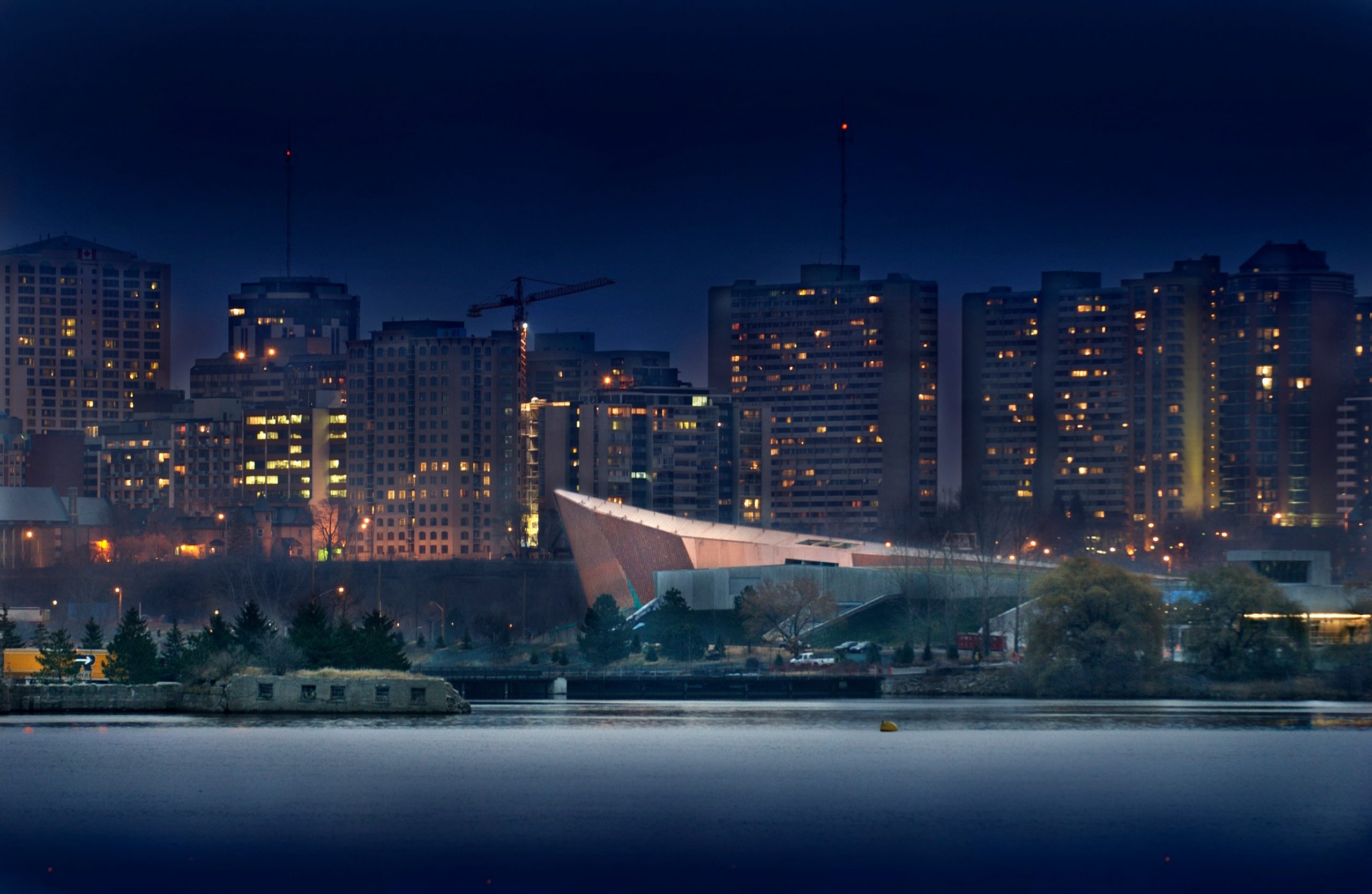 A city skyline at night in Ottawa with the Canadian War Museum.