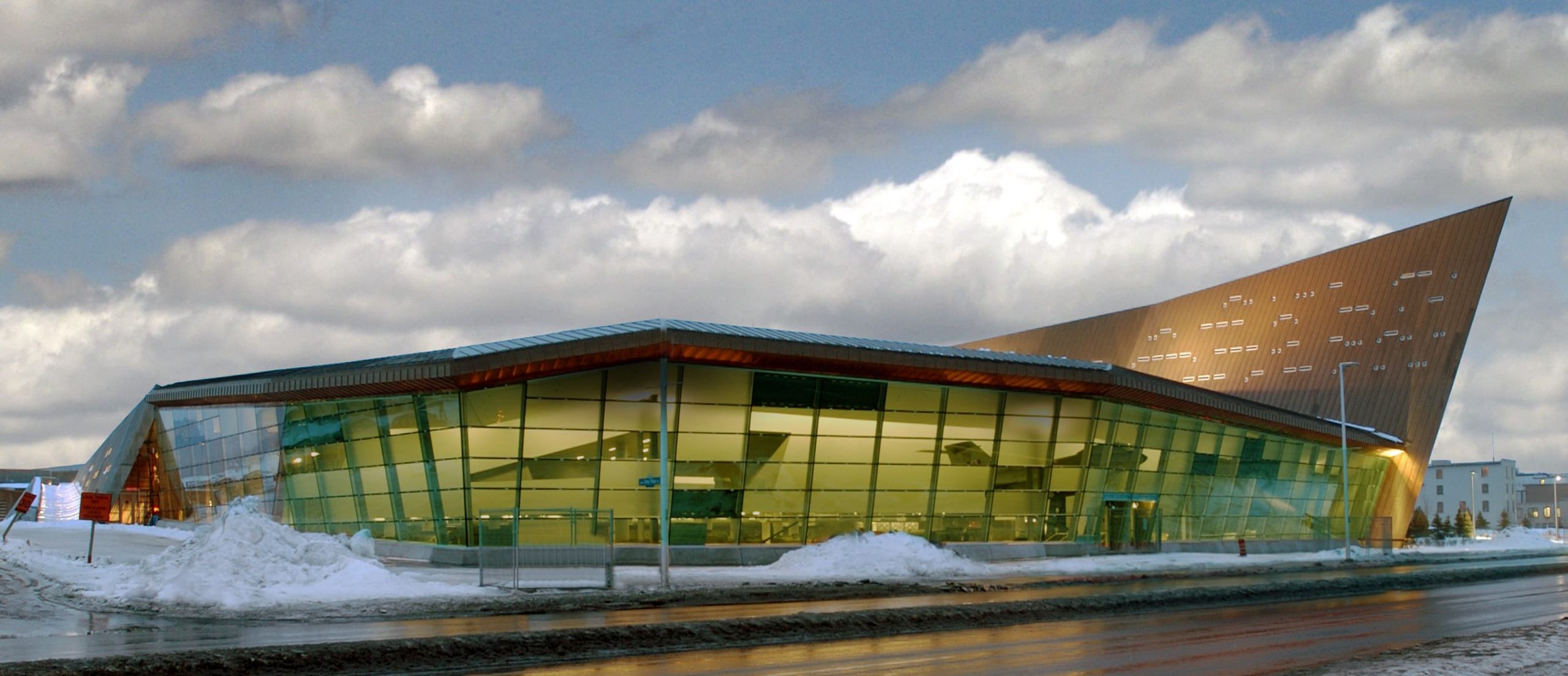 The Canadian War Museum, located in Ottawa, is a building with a green roof amidst snowy grounds.