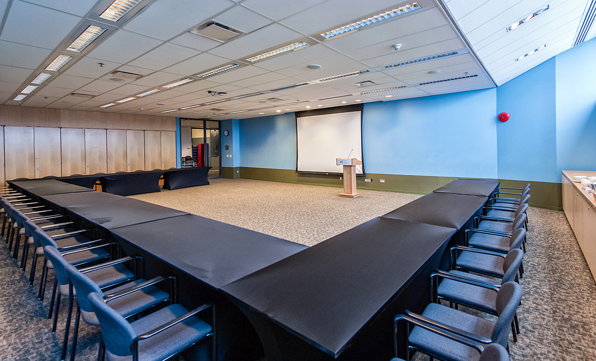 An Atelier room with chairs and a projection screen, located in Ottawa at the Canadian War Museum.