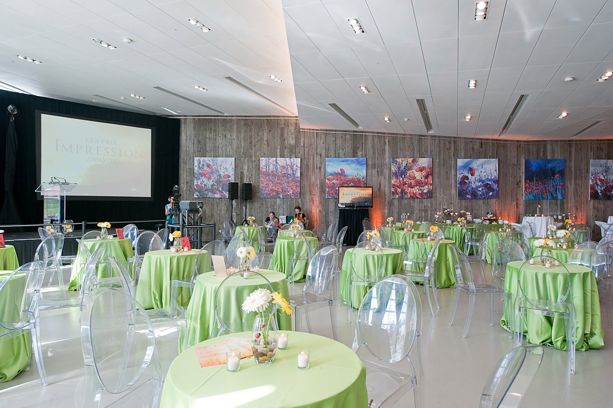 A large room with green tables and chairs in the Canadian War Museum.