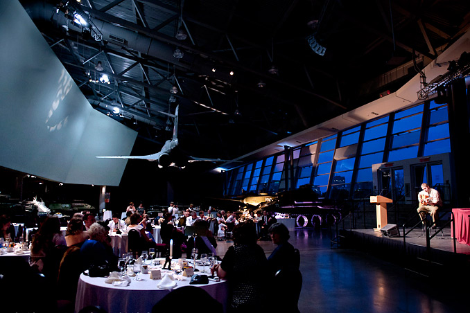 A group of people are sitting at tables in the LeBreton Gallery at the Canadian War Museum in Ottawa.