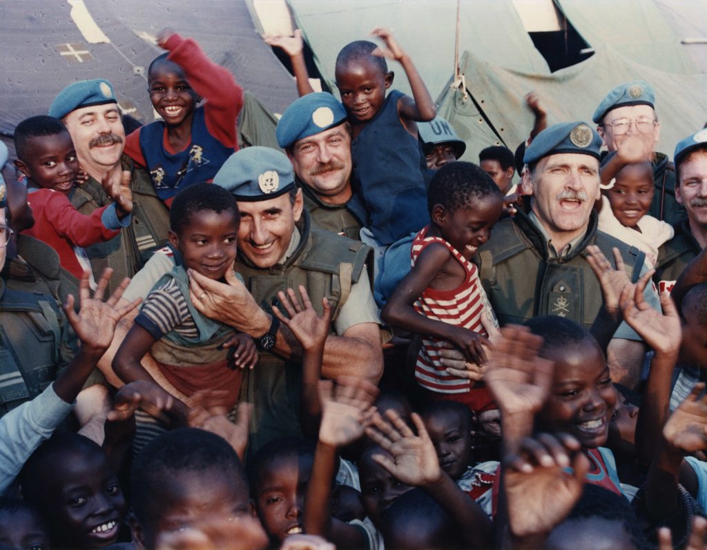 A group of military men and children are posing for a photo at the Canadian War Museum in Ottawa.