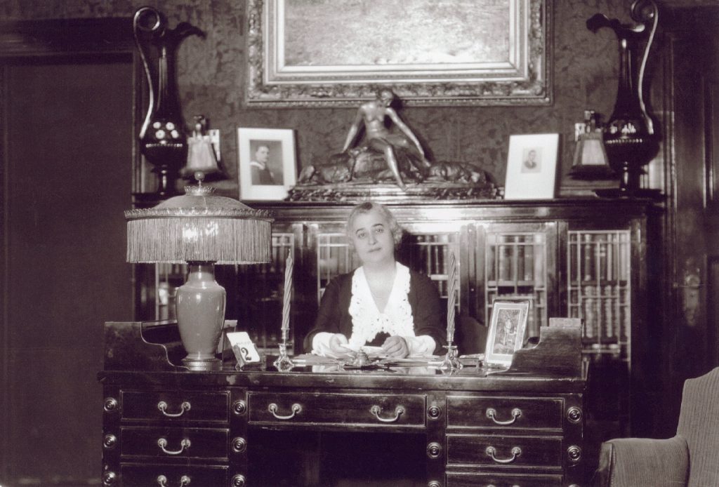 An old photo of a woman sitting at a desk in Ottawa.