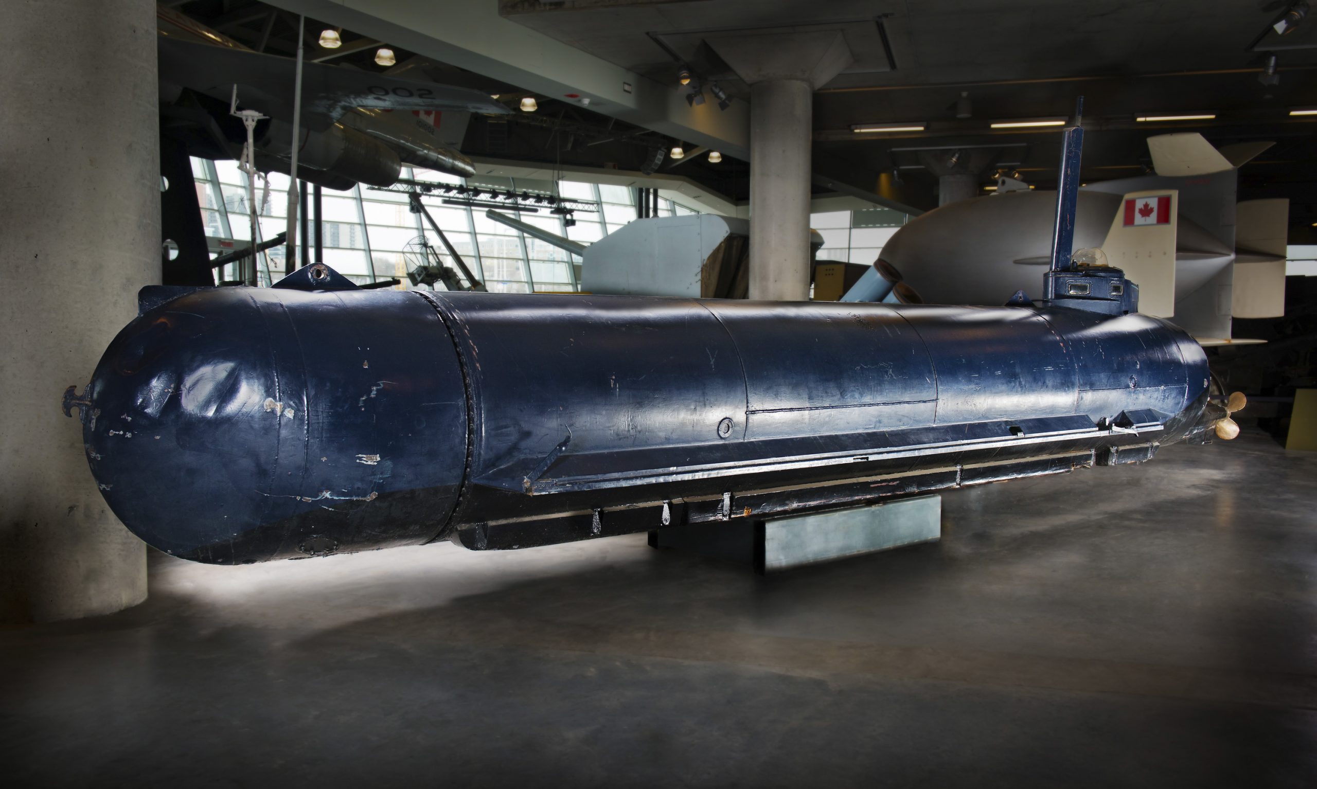 A blue submarine is on display in a museum.