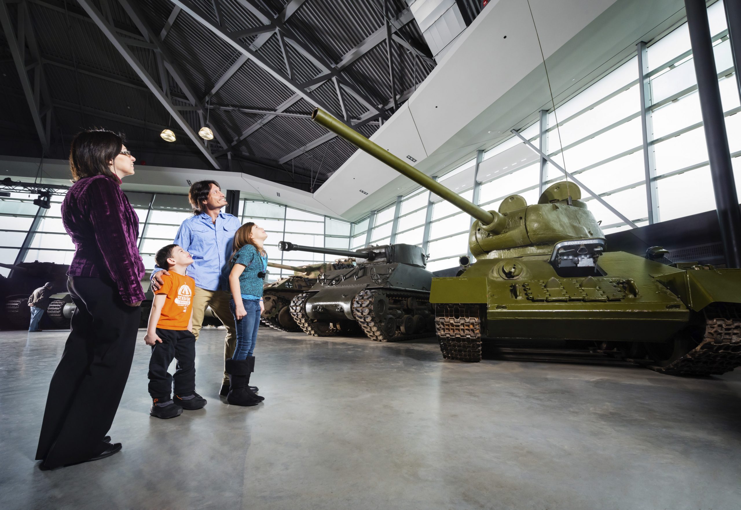 A family looking at a tank in a museum.