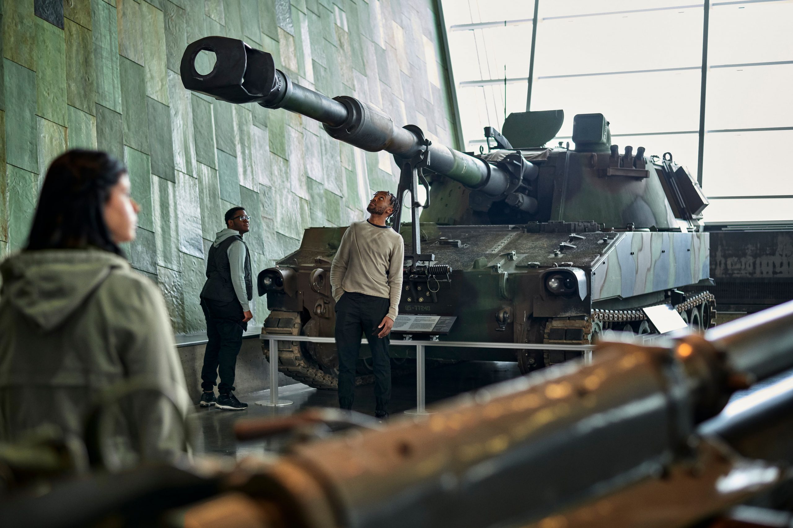 A group of people looking at a tank in the Lebreton Gallery at the Canadian War Museum.