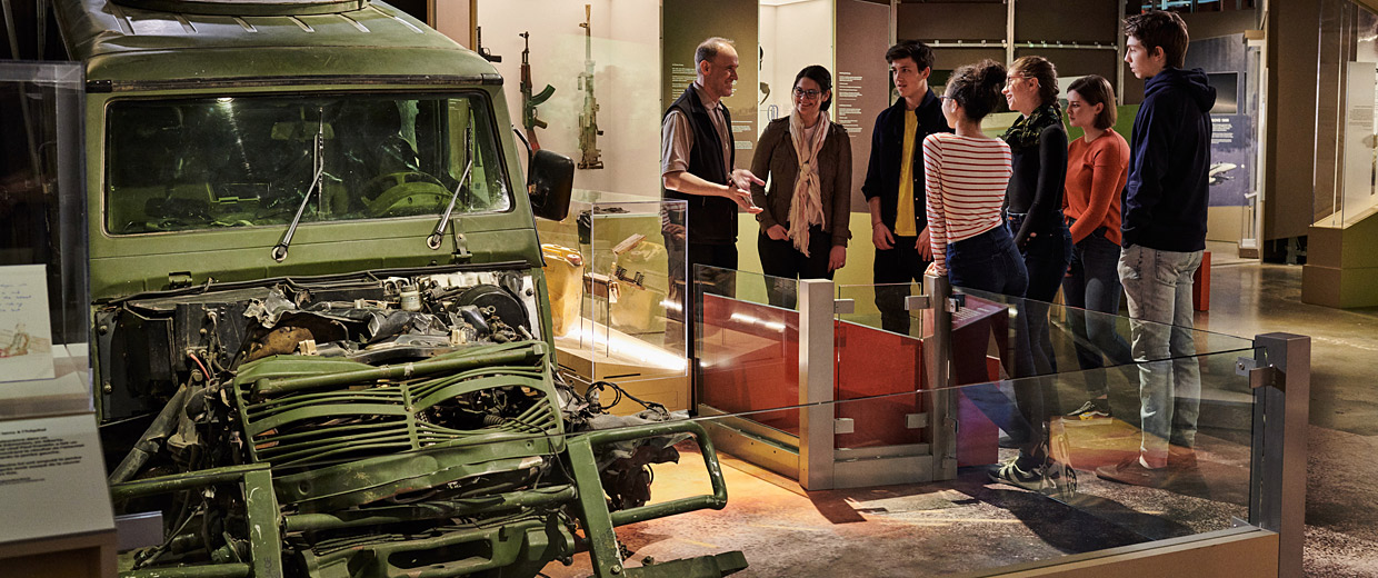 A group of people in Ottawa looking at an old truck in the Canadian War Museum.