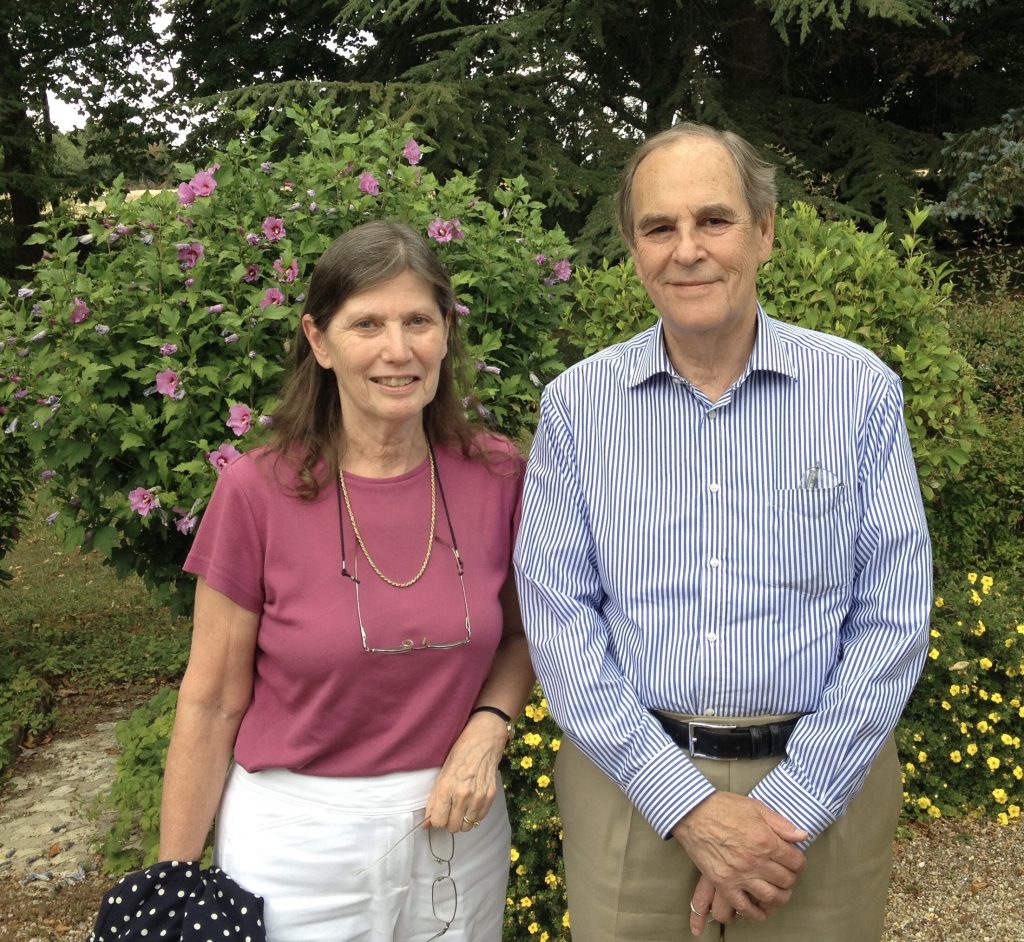 Elderly man and woman standing beside each other in a garden